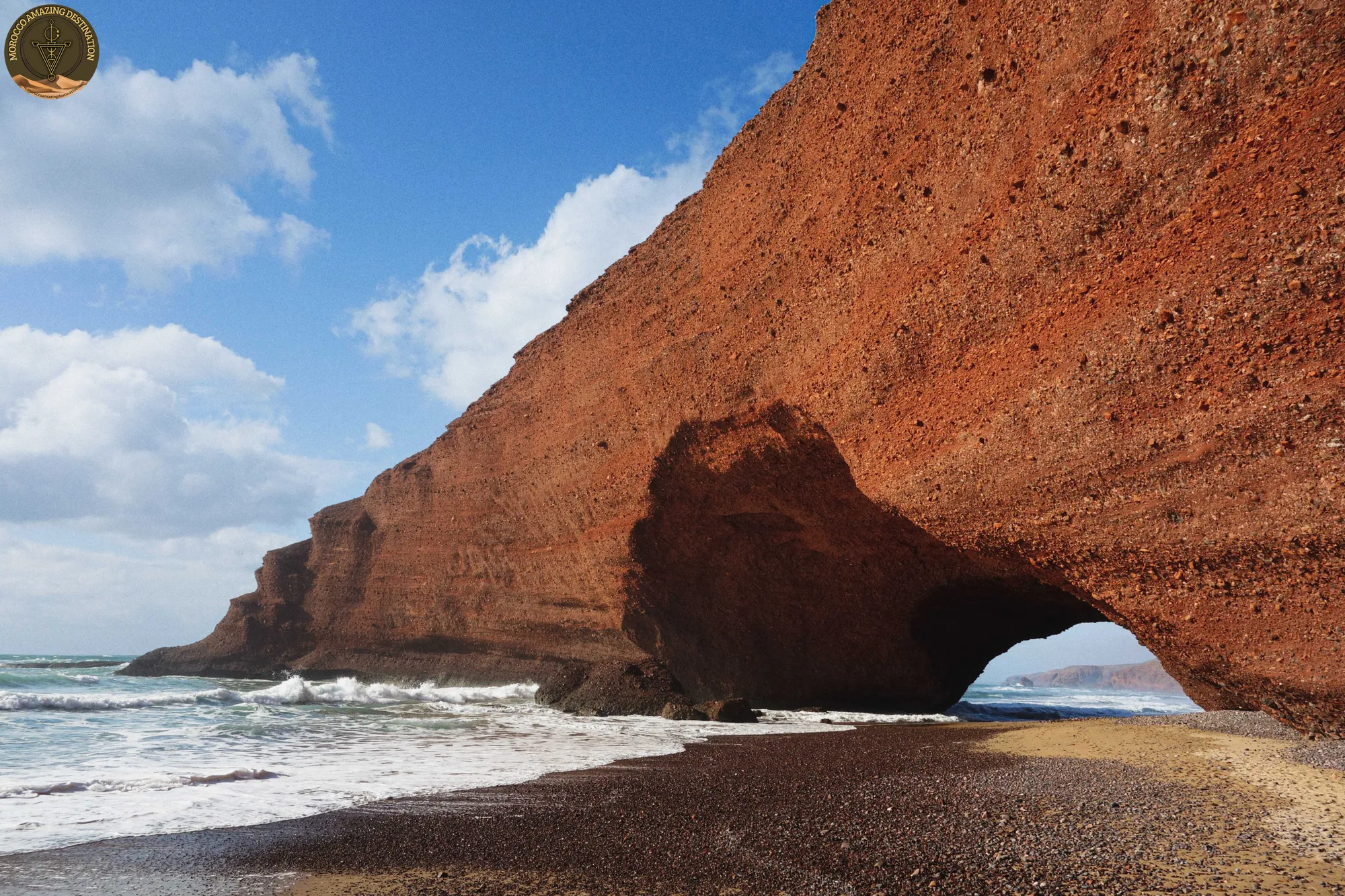 Red sandstone cliffs and natural arch at Legzira Beach near Tiznit — day trip from Agadir